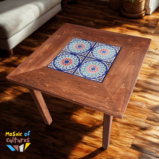 Wooden table with decorative tiles on a wooden floor, featuring 'Mosaic of Cultures' branding.