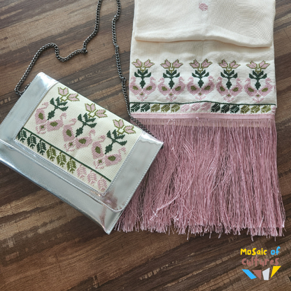 Embroidered clutch bag and scarf with floral patterns on a wooden surface, brand 'Mosaic of Cultures' visible.