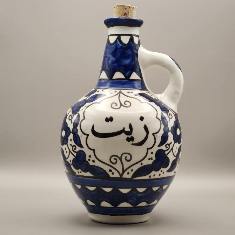 A handcrafted ceramic oil pot with a blue and white design, featuring intricate patterns and a white handle.