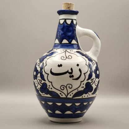 A handcrafted ceramic oil pot with a blue and white design, featuring intricate patterns and a white handle.