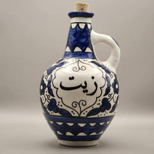 A handcrafted ceramic oil pot with a blue and white design, featuring intricate patterns and a white handle.