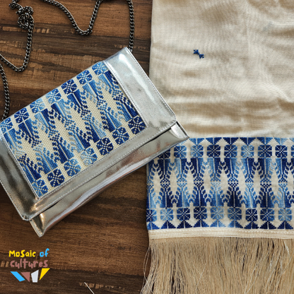 Silver clutch with blue and white pattern on a wooden surface, featuring 'Mosaic of Cultures' logo.